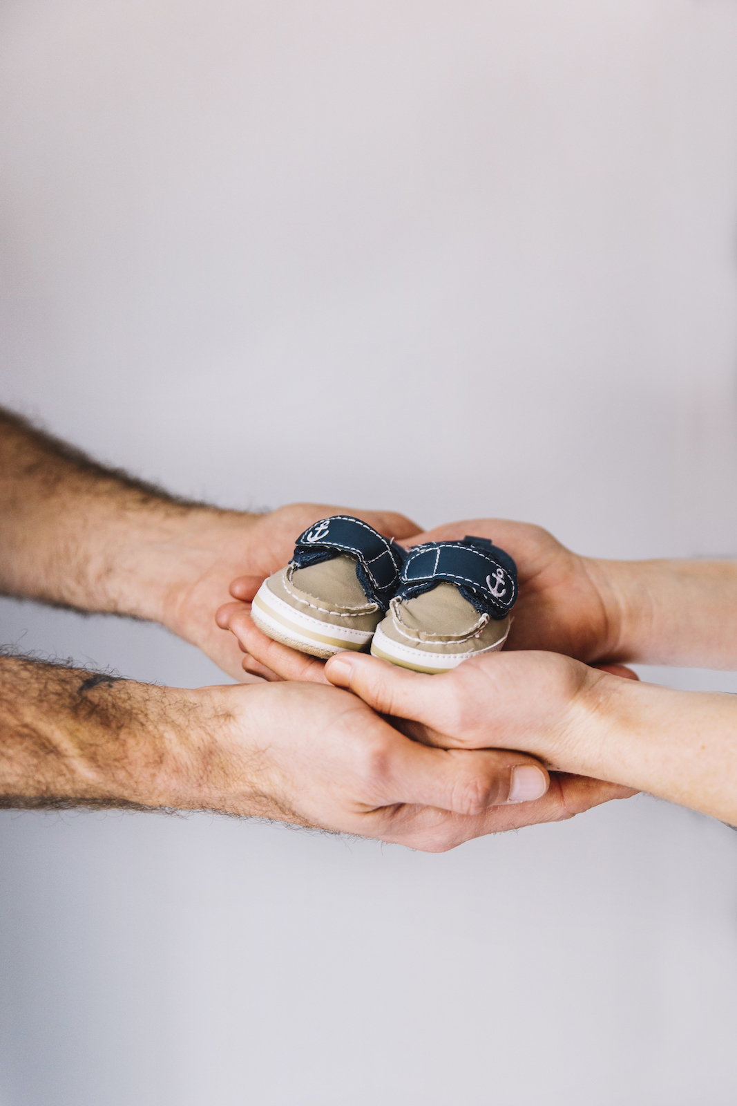 pregnant-woman-husband-with-baby-shoes